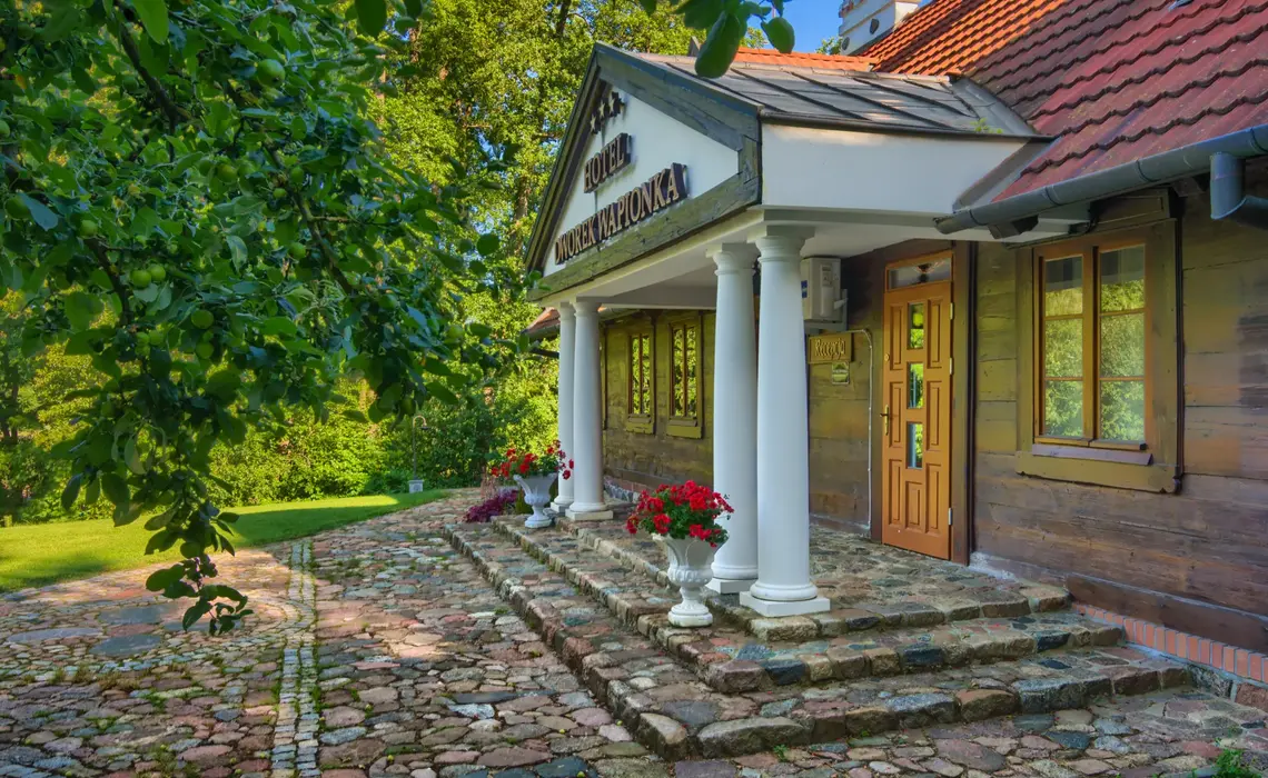 Historic building of Hotel Dworek Wapionka surrounded by greenery